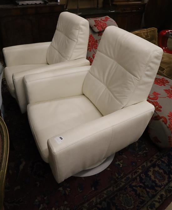 A pair of contemporary white leather swivel armchairs